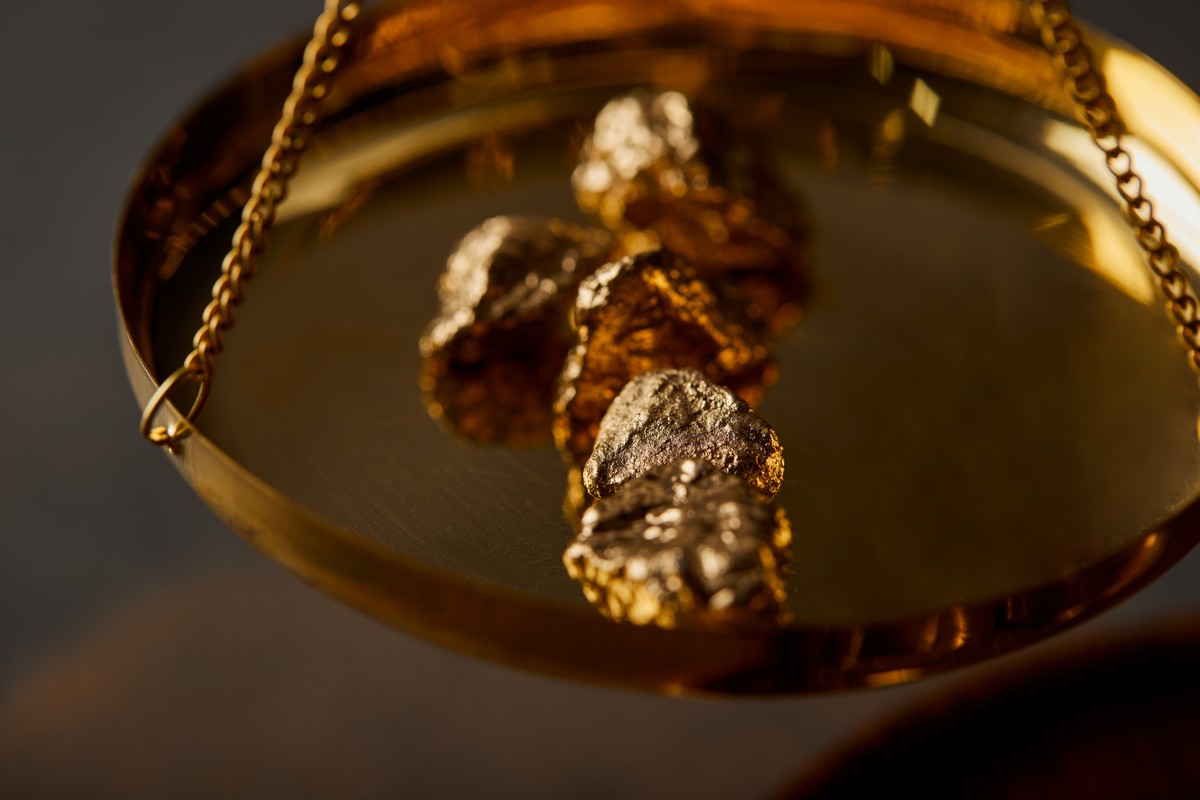 selective focus of golden stones on scales on grey background