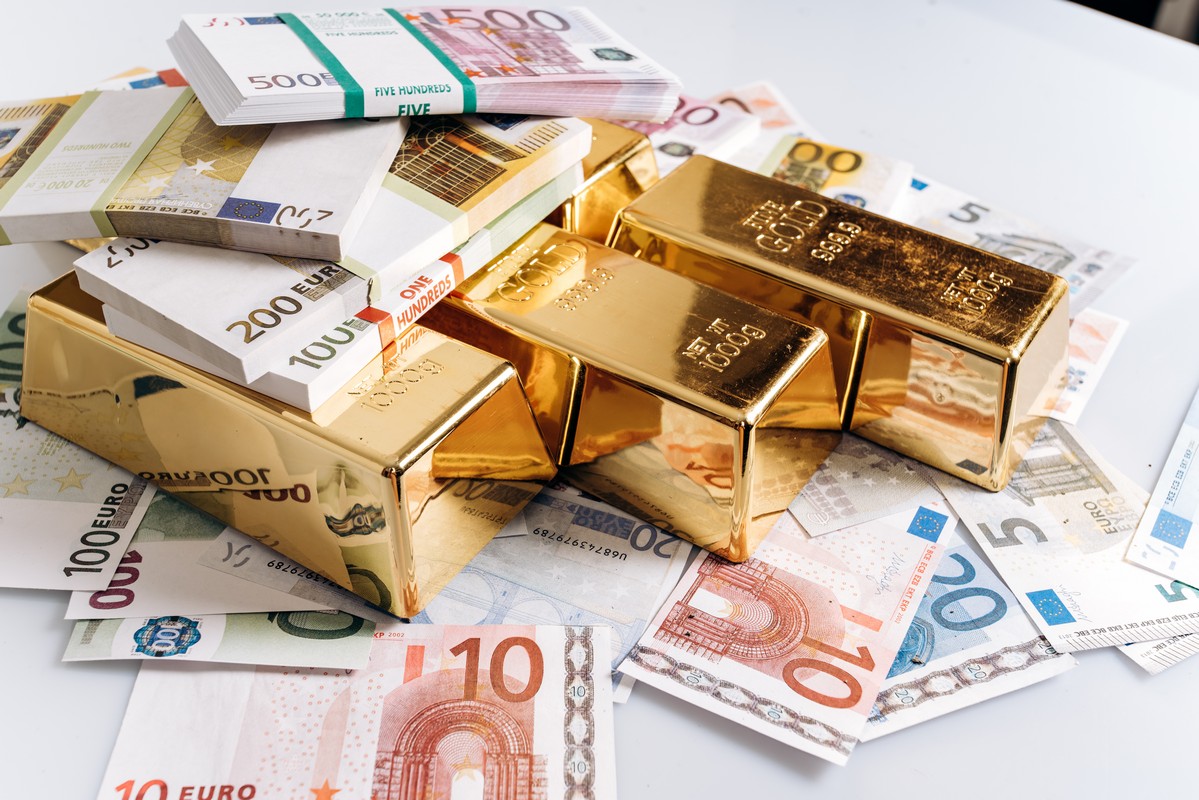 Gold bullions at euro banknotes closeup background